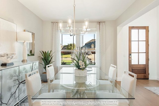 dining room with light wood-type flooring and an inviting chandelier