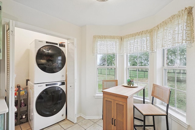 laundry room with stacked washer and dryer and light tile patterned floors