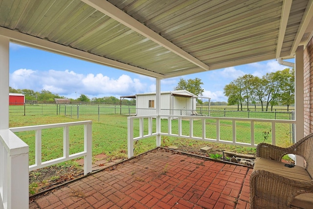 view of patio featuring a rural view and an outbuilding