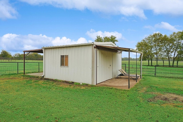 view of outbuilding featuring a rural view and a yard