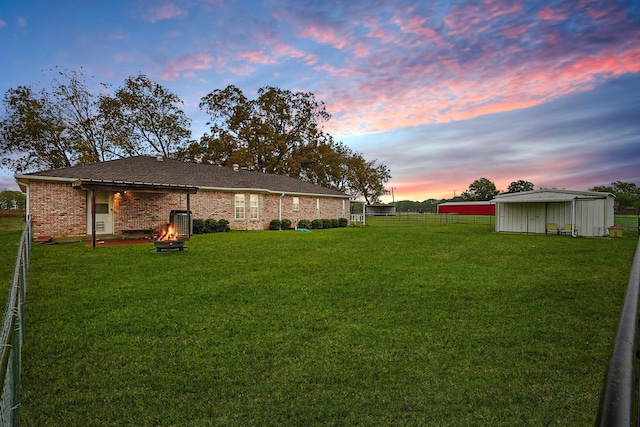 yard at dusk featuring an outbuilding