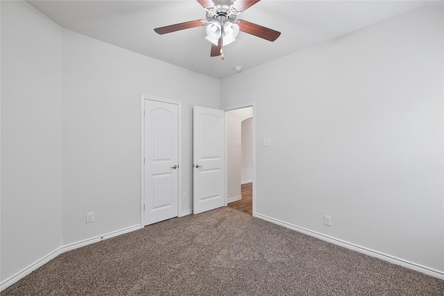 unfurnished bedroom with ceiling fan and dark colored carpet