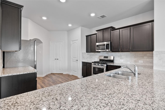 kitchen featuring sink, stainless steel appliances, and light stone countertops