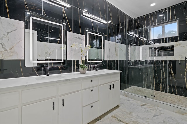 bathroom with double vanity, marble finish floor, a marble finish shower, and a sink