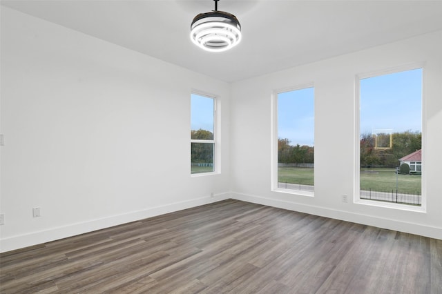 spare room with dark wood-type flooring and baseboards