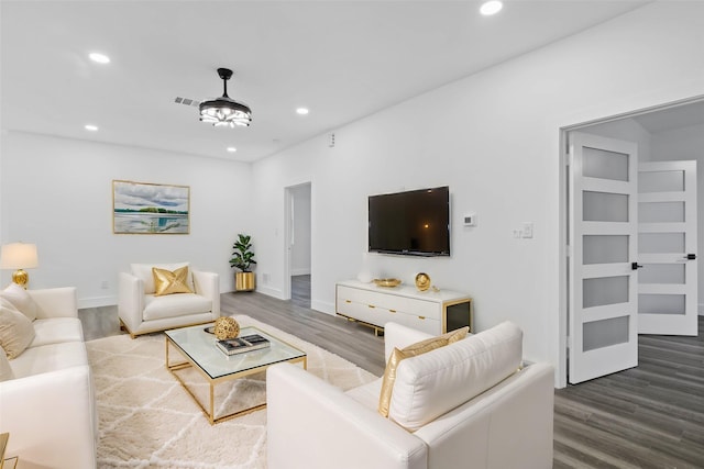 living room featuring baseboards, visible vents, dark wood finished floors, and recessed lighting