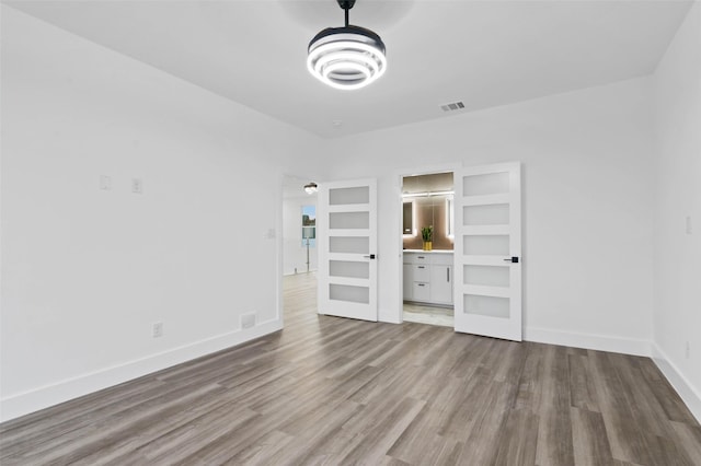 interior space with baseboards, visible vents, and wood finished floors