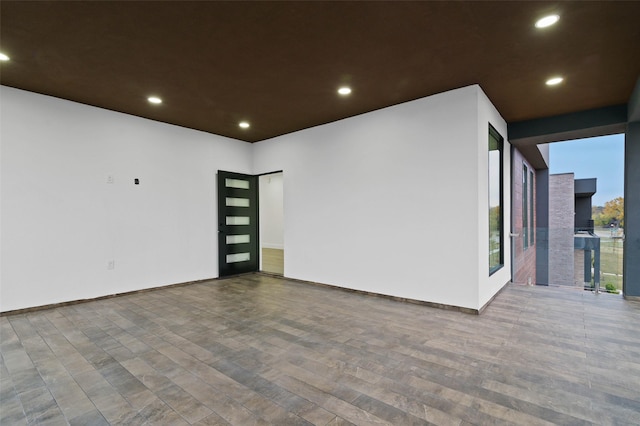 spare room featuring baseboards, wood finished floors, and recessed lighting