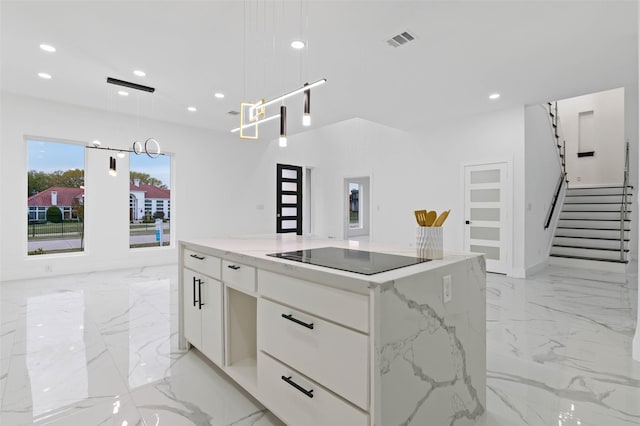 kitchen featuring marble finish floor, black electric stovetop, visible vents, and white cabinetry