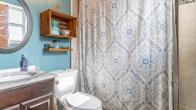 bathroom with curtained shower, vanity, and toilet