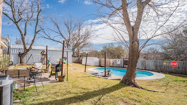 view of pool featuring a lawn, central air condition unit, a patio, and grilling area