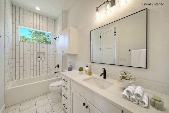 full bathroom featuring tiled shower / bath, vanity, and toilet