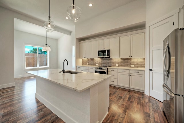 kitchen featuring stainless steel appliances, sink, a center island with sink, and white cabinets