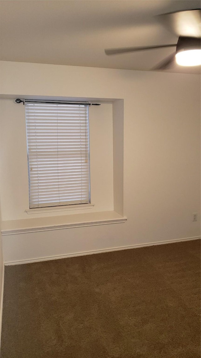 unfurnished room featuring ceiling fan and dark carpet