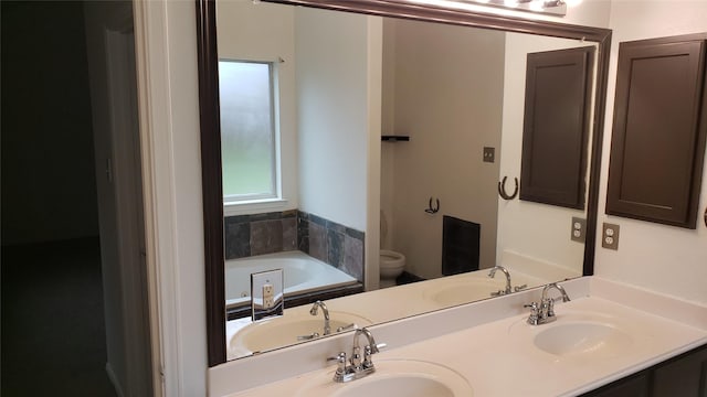 bathroom featuring vanity, toilet, and a tub