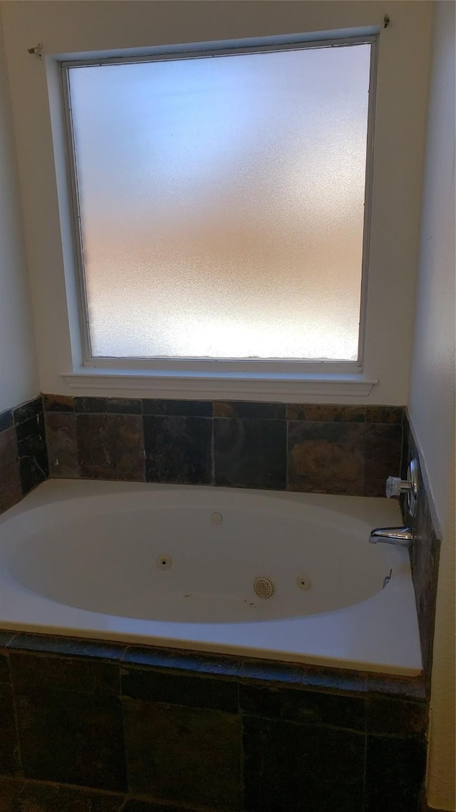 bathroom with a relaxing tiled tub