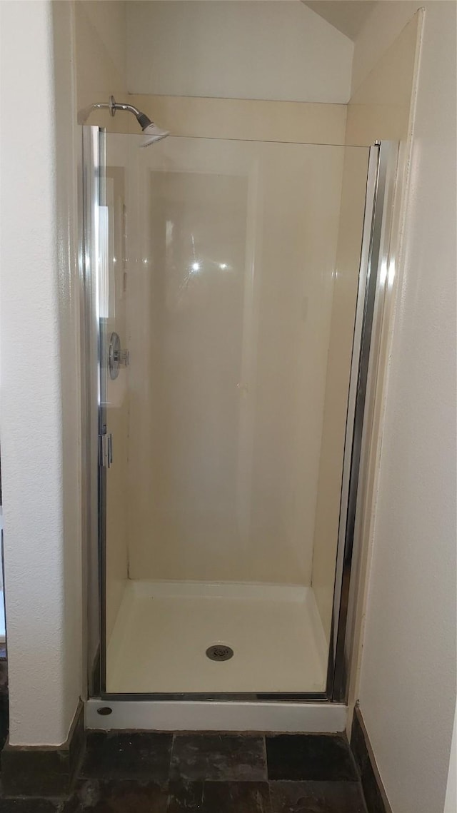 bathroom featuring a shower with door