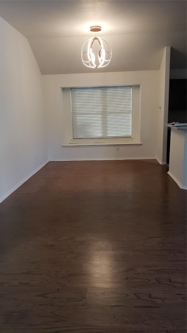 unfurnished dining area with vaulted ceiling, dark hardwood / wood-style floors, and an inviting chandelier