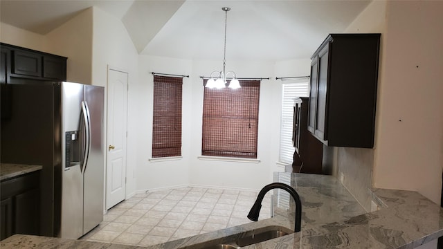 kitchen featuring a notable chandelier, decorative light fixtures, stainless steel fridge, and light tile patterned floors