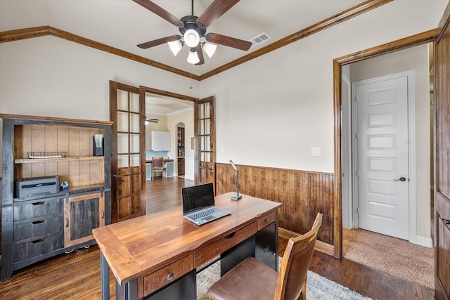 office with arched walkways, wainscoting, ceiling fan, dark wood-type flooring, and wood walls