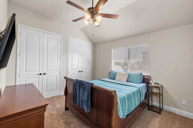 bedroom with multiple closets, lofted ceiling, a ceiling fan, carpet flooring, and baseboards