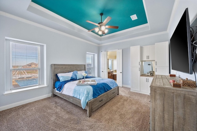 bedroom with light carpet, a tray ceiling, crown molding, and baseboards