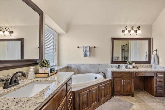 full bathroom with a garden tub, two vanities, and a sink