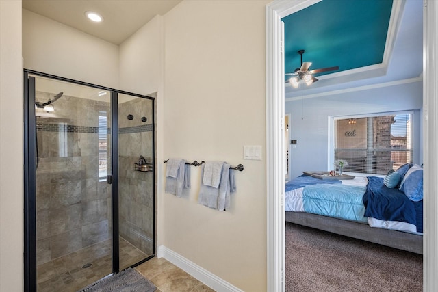 full bath featuring crown molding, a raised ceiling, connected bathroom, a shower stall, and baseboards