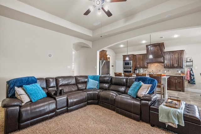 living area with arched walkways, recessed lighting, visible vents, a ceiling fan, and baseboards