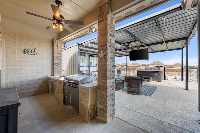 view of patio featuring a hot tub, an outdoor kitchen, area for grilling, fence, and a sink