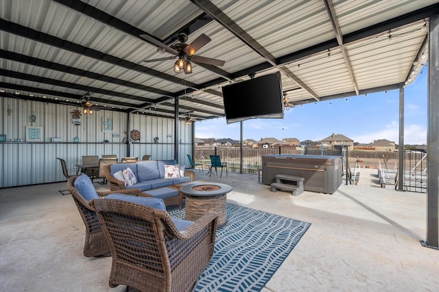 view of patio / terrace featuring a hot tub, an outdoor living space with a fire pit, ceiling fan, a residential view, and fence