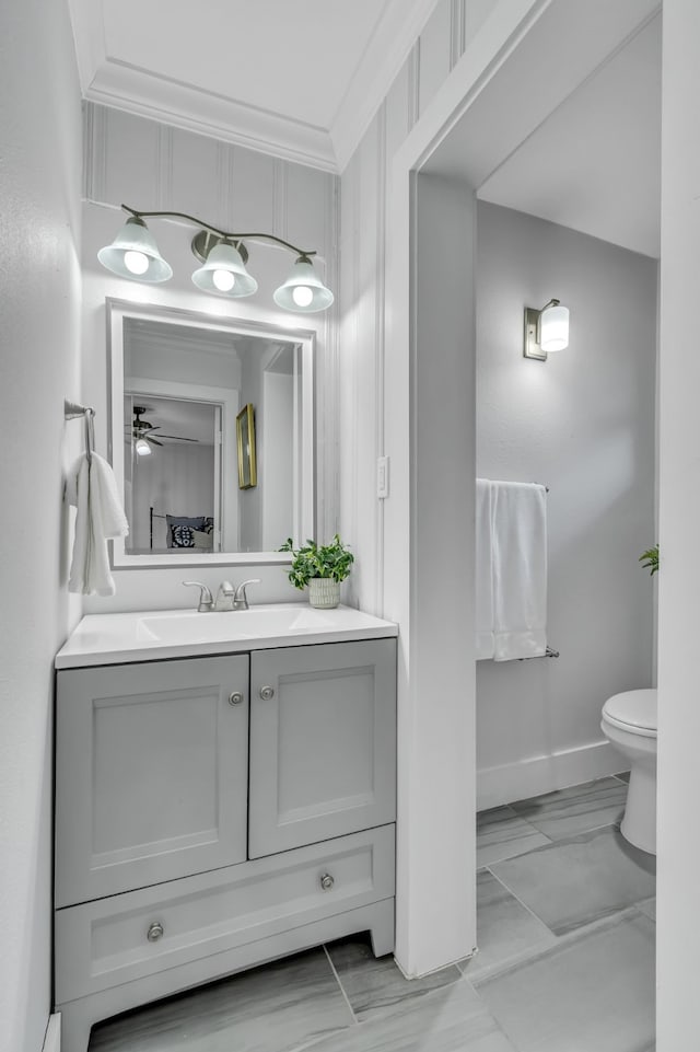 bathroom featuring vanity, toilet, ceiling fan, and crown molding