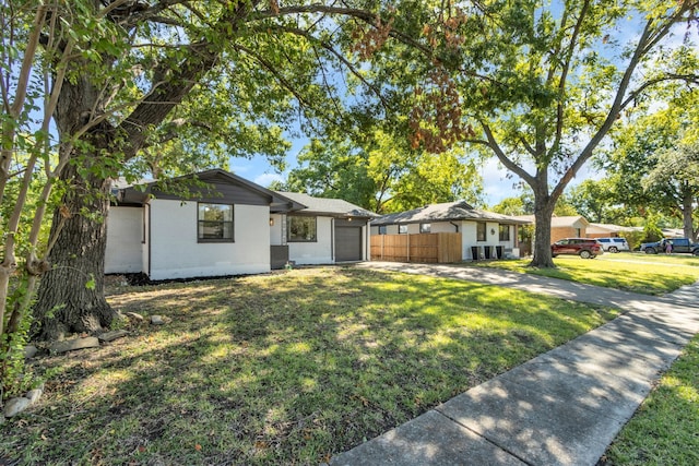 view of front of home with a front yard and a garage