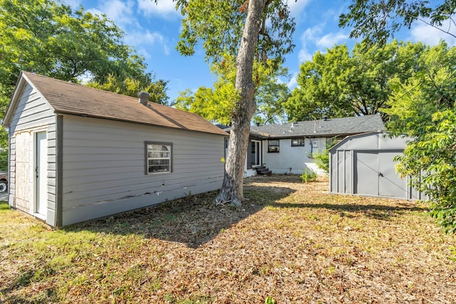 rear view of house with a storage shed