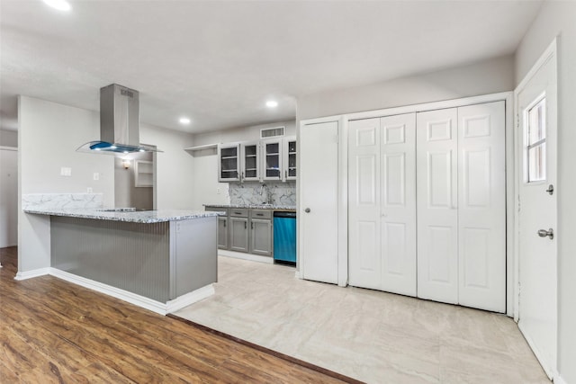 kitchen featuring sink, stainless steel dishwasher, kitchen peninsula, decorative backsplash, and exhaust hood