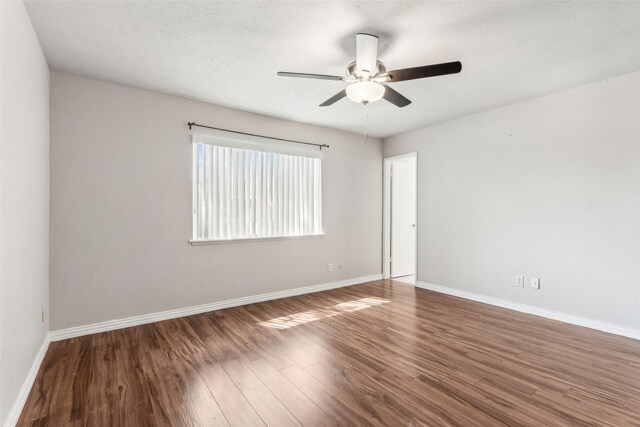 empty room featuring ceiling fan and dark hardwood / wood-style flooring