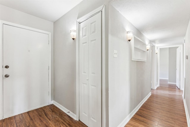 hallway featuring a textured ceiling and dark wood-type flooring