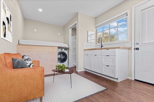 washroom with hardwood / wood-style flooring, sink, and washer / dryer