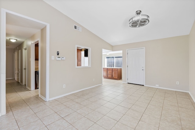 tiled empty room with lofted ceiling