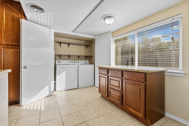 washroom with light tile patterned floors and washing machine and clothes dryer