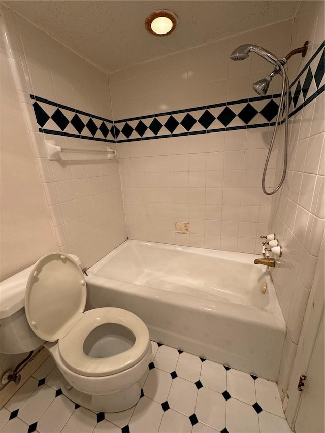 bathroom featuring tiled shower / bath combo and toilet