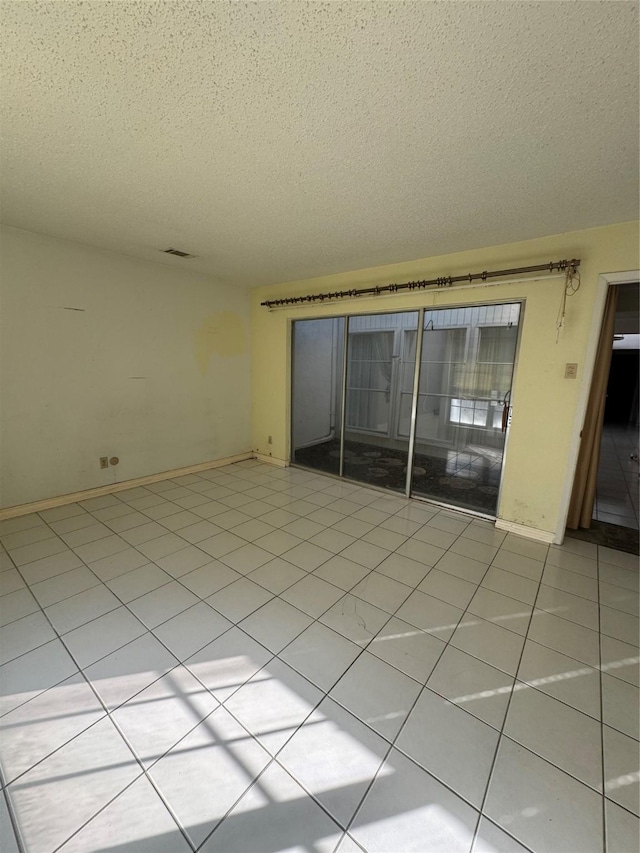 tiled spare room with a textured ceiling