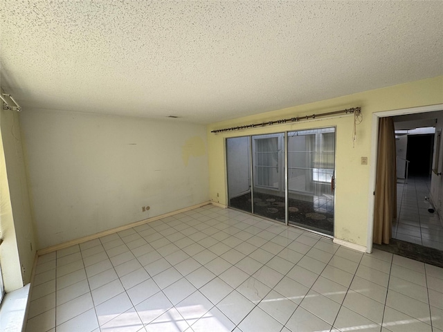 unfurnished room featuring light tile patterned flooring and a textured ceiling