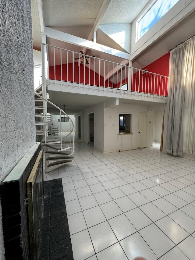 interior space featuring tile patterned floors, beamed ceiling, and high vaulted ceiling