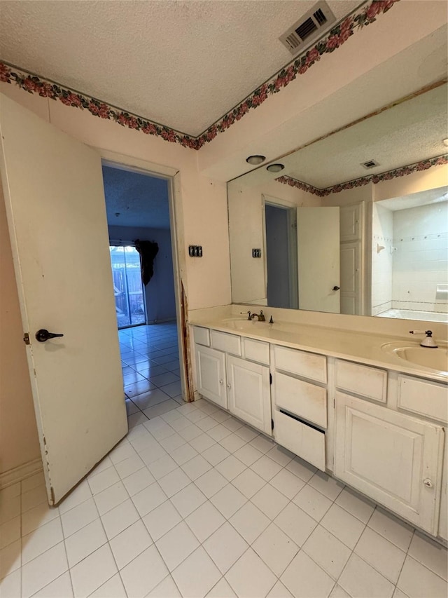 bathroom featuring tile patterned floors, vanity, and a textured ceiling