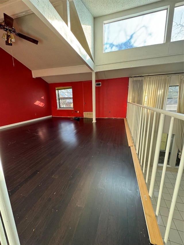 hallway featuring beamed ceiling, a textured ceiling, dark hardwood / wood-style floors, and high vaulted ceiling