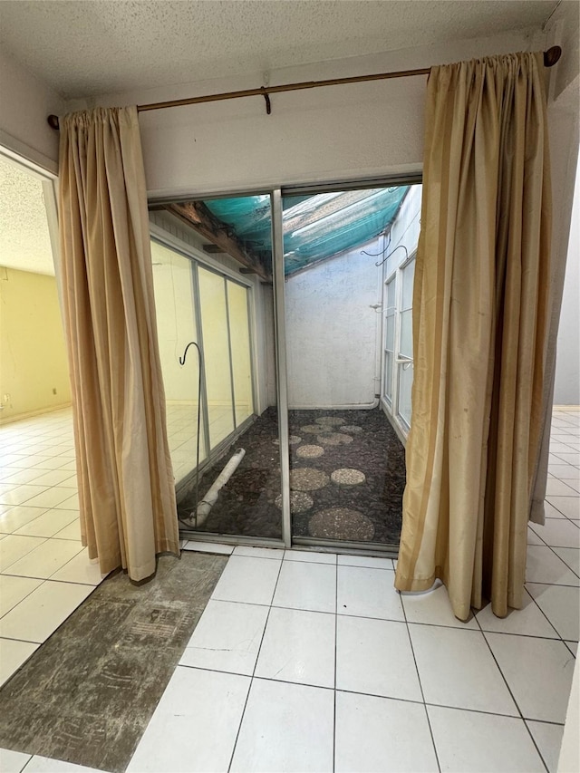 interior space with tile patterned flooring and a textured ceiling