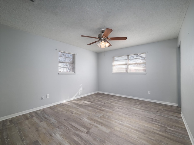 unfurnished room with hardwood / wood-style flooring, a textured ceiling, and a healthy amount of sunlight