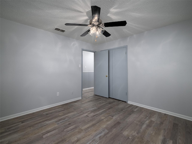 unfurnished bedroom with a closet, ceiling fan, dark wood-type flooring, and a textured ceiling