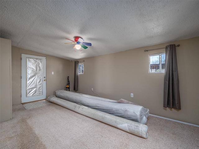 carpeted bedroom with ceiling fan and a textured ceiling
